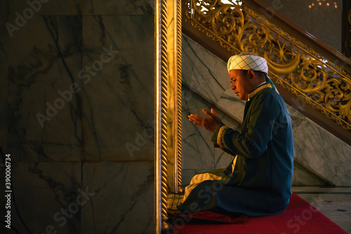 muslim man having worship and praying in islam ceremony in mosque photo