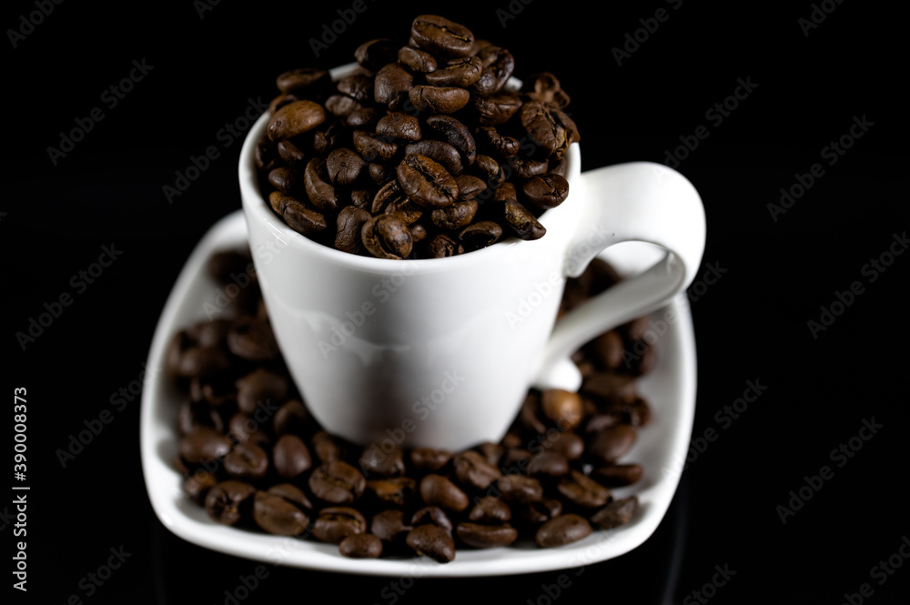 Espresso coffee mug on a black background full of coffee beans Espresso coffee mug on a black background full of coffee beans