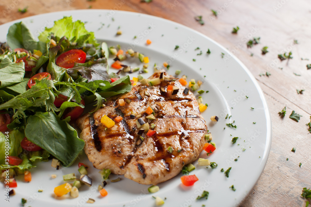 Grilled chicken with green salad and sweet cherry on wooden table Grilled chicken with green salad and sweet cherry on wooden table