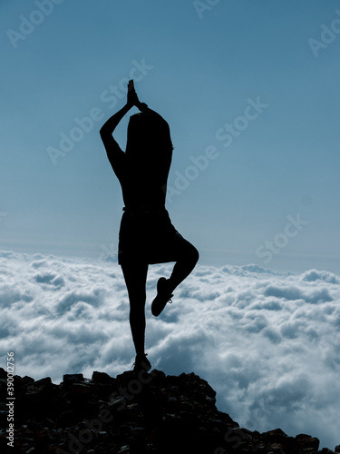 yoga pose silhouette above the clouds
