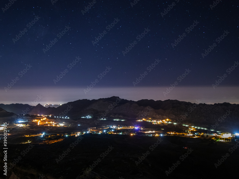 stars above a town and a mountain range