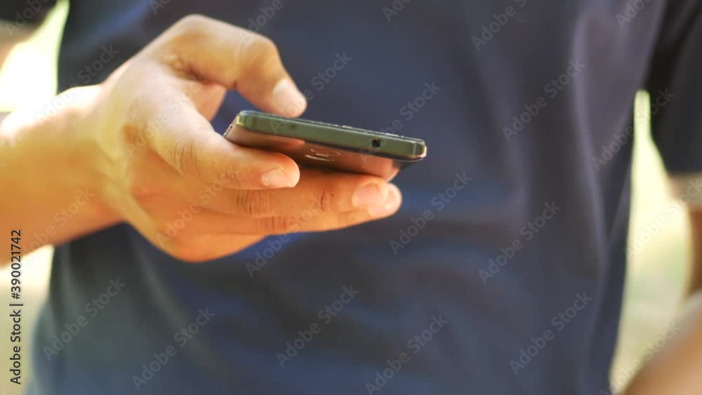 Front view an Indonesian young man using apps on a touchscreen smartphone - Concept for using technology, shopping online, using mobile apps, texting, phone addiction.