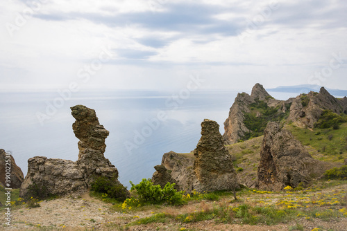 View of the rocks of the Kara-Dag mountain range against the sea and cloudy sky on the Crimean Peninsula