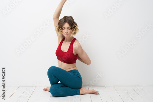 woman doing yoga full length indoors blue leggings red tank top