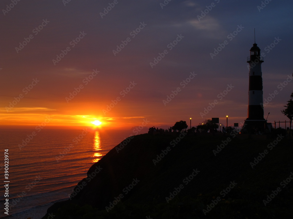 Miraflores lighthouse looking at the sunset in front of the sea