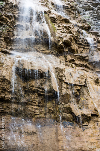 Close-up view of the waterfall streams flowing down the rocks of the mountain