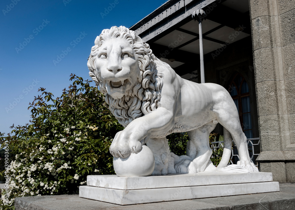 Stone lion in the park of the Vorontsov Palace built in the 19th century near the Crimean mountains in Alupka, Russia