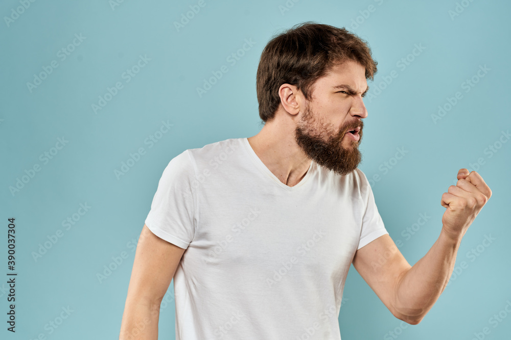 Man gestures with his hands emotions displeasure white t-shirt blue background Man gestures with his hands emotions displeasure white t-shirt blue background
