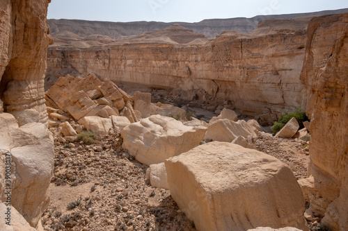 Hiking trail in wadi Zafit, Negev desert, Israel. Desert landscape with limestone mountains, sandy hills, rock formations and huge boulders.