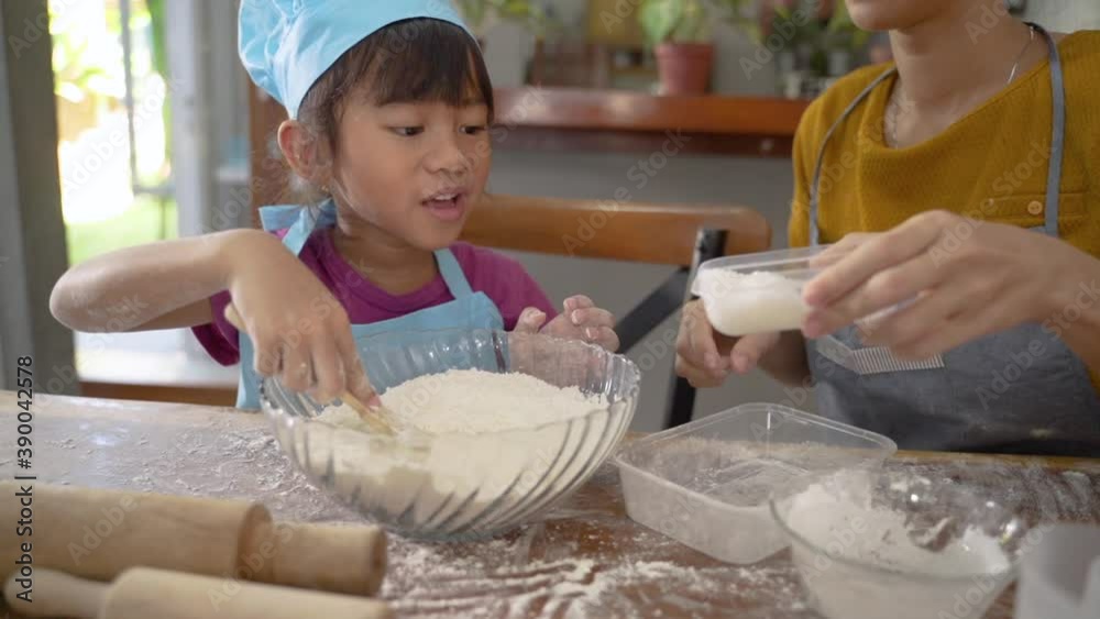 Mom and little cute girl in chef clothes, smiling and making homemade pizza at home in kitchen Mom and little cute girl in chef clothes, smiling and making homemade pizza at home in kitchen