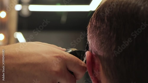 barber cuts a man's hair with a shaving machine