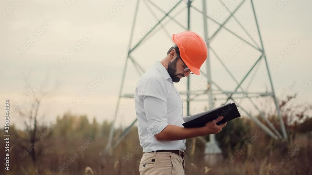 Electrical Engineer In Helmet On Power Lines.Technician Inspect High Voltage Tower.Engineer In Hardhat Maintenance Electricity Transmission Pylon.Technician Check High Voltage Sensor Power Line Wires. Electrical Engineer In Helmet On Power Lines.Technician Inspect High Voltage Tower.Engineer In Hardhat Maintenance Electricity Transmission Pylon.Technician Check High Voltage Sensor Power Line Wires.