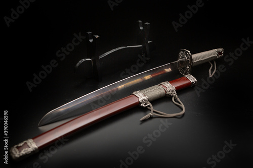 Beautiful katana sword with sheath and stand on a black background photo