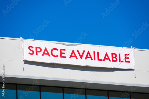 Photography Space Available large banner sign on vacant commercial office building facade advertising the real estate, property, office for sale, rent or lease