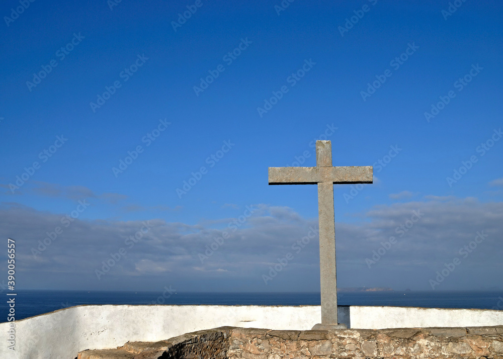Religious  stone cross in front of blue sky