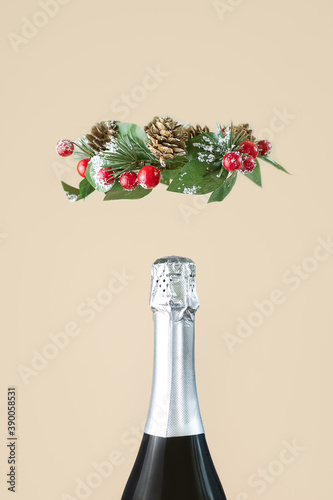 Neck of a champagne bottle with silver foil and a Christmas wreath close-up. The concept of a celebration, holiday, new year. Minimalism, copy space.