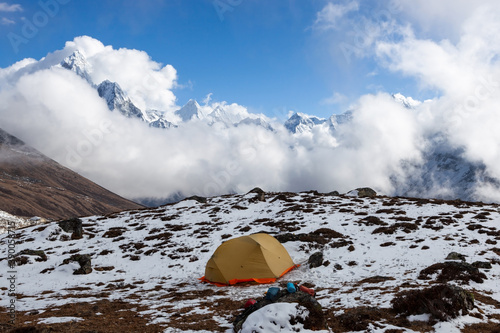 Camping in Himalayas. Single yellow tent on the snowy ground. Everest base camp trek.