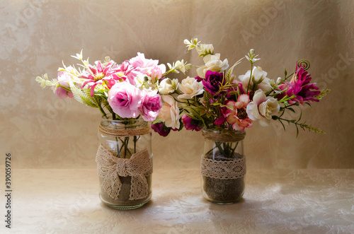 Close-up of gentle floral compositions in vases on the beige background