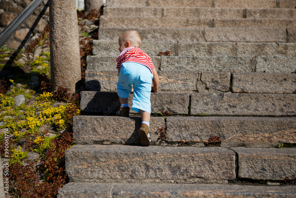 child playing on a steep stone staircase