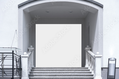 big white billboard in doorway of hotel building with stone staircase