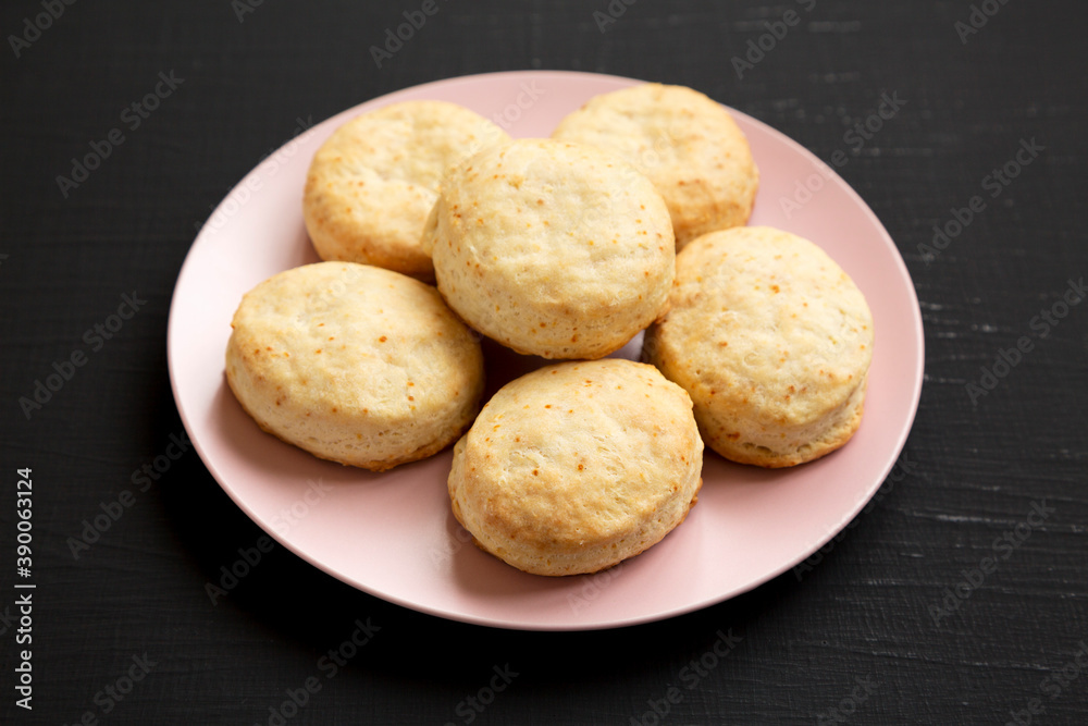Homemade Flaky Buttermilk Biscuits on a pink plate on a black background, side view. Close-up. Homemade Flaky Buttermilk Biscuits on a pink plate on a black background, side view. Close-up.