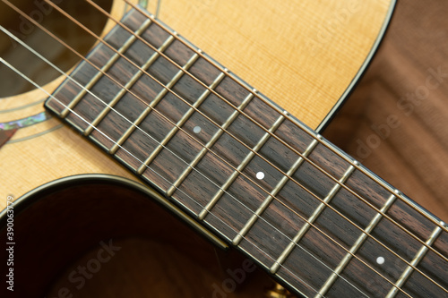 Close-up shot of acoustic guitar fingerboard made of ebony wood photo