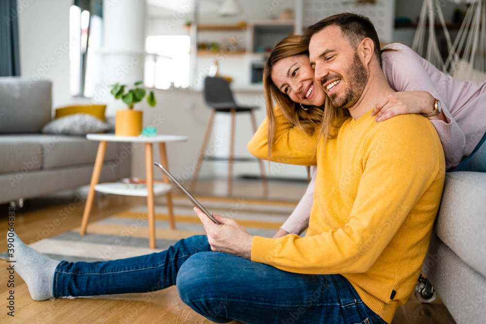 Couple in love hugging and using tablet together. Couple in love hugging and using tablet together.