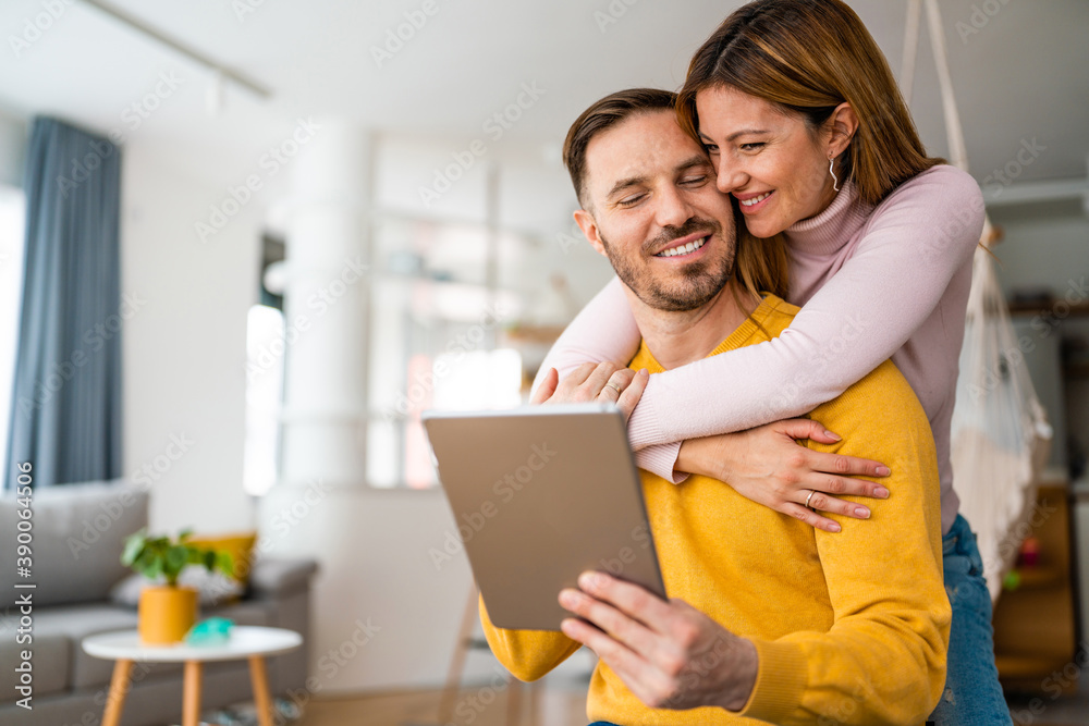 Happy couple spending time with tablet at home Happy couple spending time with tablet at home