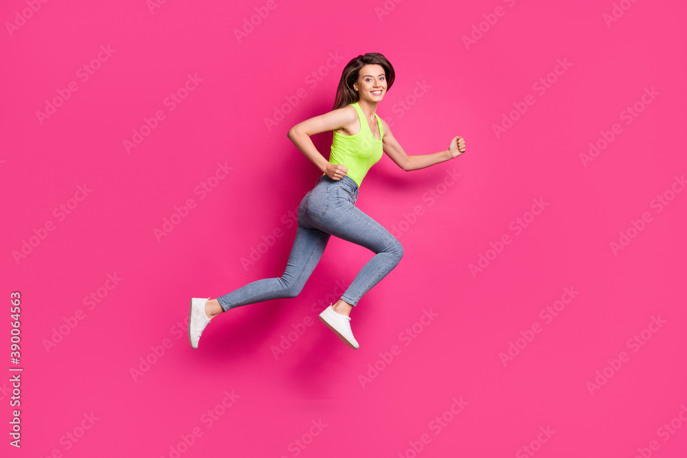Full body profile side photo of happy positive brown hair girl jump run hurry fists hands isolated over pink color background