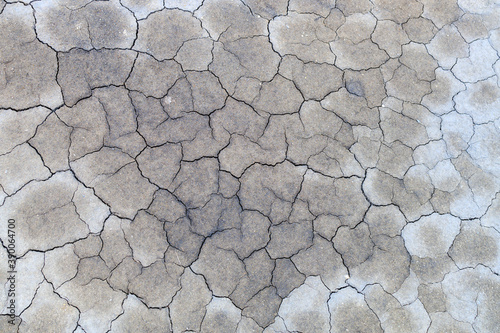 cracks from drought on gray weathered earth