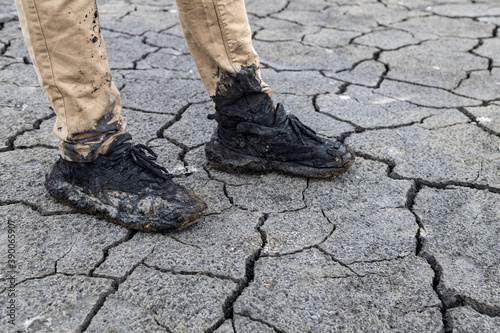 dirty shoes on the background of cracked earth