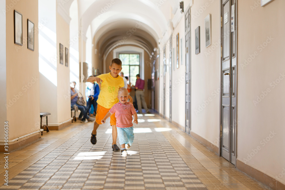 funny little children running along the university corridor
