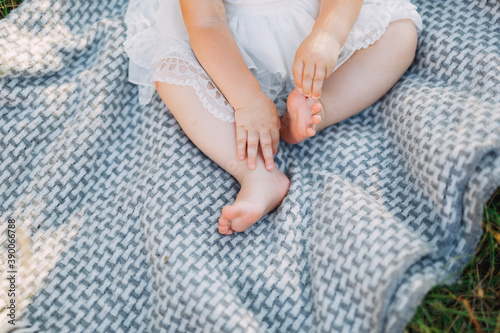 little legs of a girl sitting on a mat outdoors