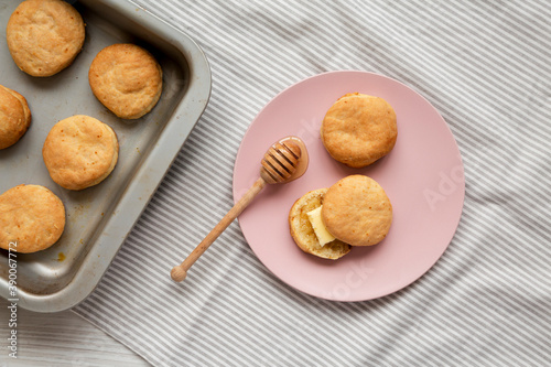Homemade Flaky Buttermilk Biscuits on a pink plate on a white wooden background, top view. Flat lay, overhead, from above.