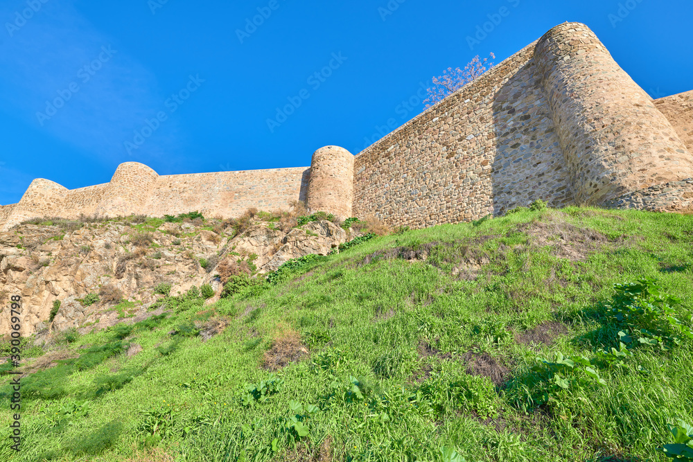 Landscape low angle view of the imposing medieval stone walls from the historic center of the city of Toledo, Castilla la Mancha, Spain