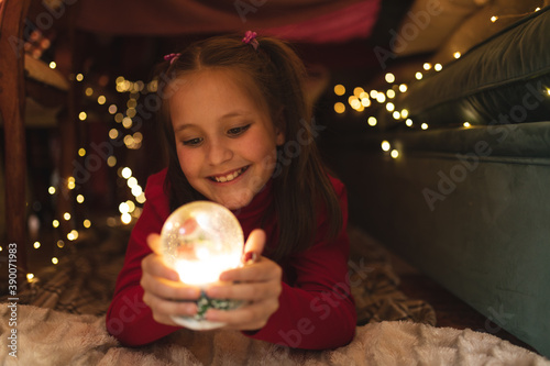 Caucasian girl smiling and holding snowglobe photo