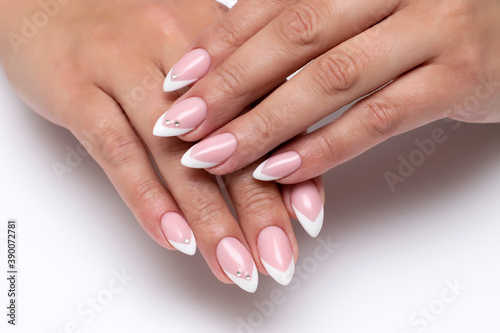 Wedding french sharp white manicure with crystals on long sharp nails close-up on a white background 