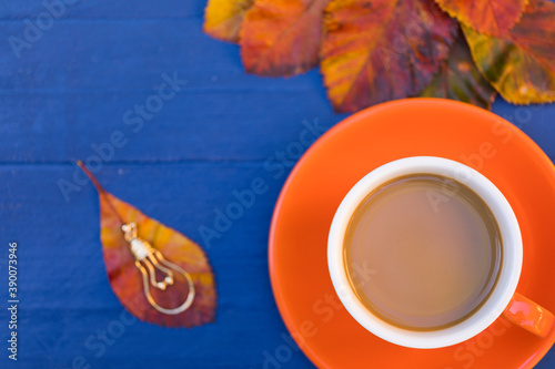 But Coffee is First: Creative Autumn Flat Lay Top View Cup of Latte Over Vintage Lamp Idea Inspiration and Bright Leaves – Navy Blue Wooden Table Background, Copy Space. Fall Season Blog Social Media