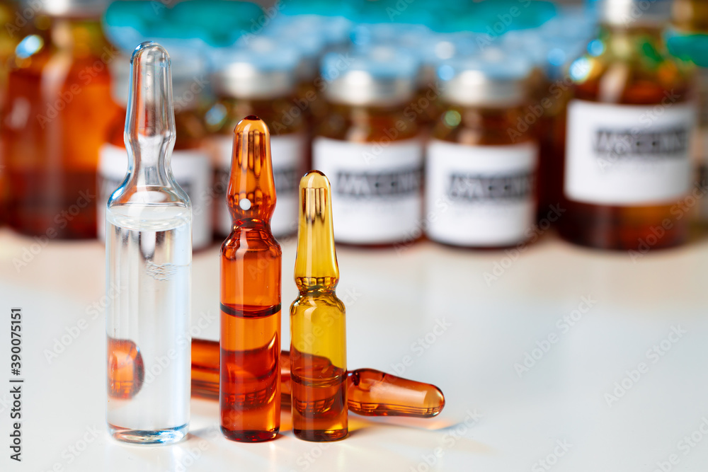 Pile of glass medical vials with medication on lab table Pile of glass medical vials with medication on lab table
