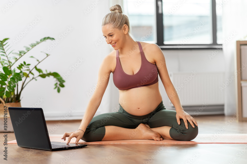 sport and people concept - happy pregnant woman doing yoga at home