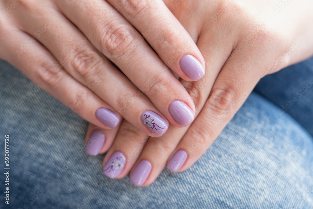 Closeup top view photography of two beautiful manicured female hands with trendy professional long lasting pastel purple painted nails with modern gel nailpolish Closeup top view photography of two beautiful manicured female hands with trendy professional long lasting pastel purple painted nails with modern gel nailpolish