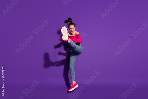 Full length body size view of strong cheerful girl fighting invisible enemy judo art isolated bright violet color background