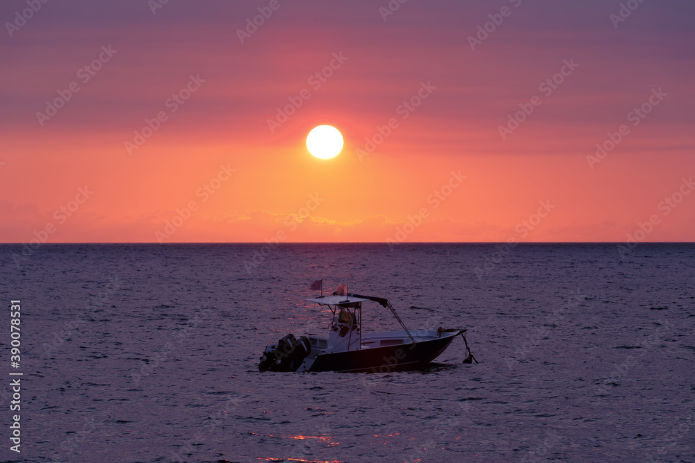 Sunset over indian ocean, Madagascar Nosy be beach with boat silhouette. Travel Africa for vacation concept.