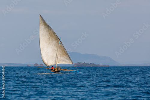 Malagasy fisher man on sea in traditional handmade dugout wooden sailing boat. Everyday life on Nosy be island. Nosy be, Madagascar