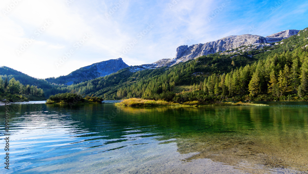 Wonderful vacations on the region Salzkammergut in Austria; hiking on the waterside  of the lakes on the Tauplitz-Alm (alpine pasture); panoramic view with hills and reflections on the water.