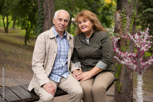 Happy old elderly caucasian couple smiling in park on sunny day, senior couple relax in spring autumn time. © Marharyta