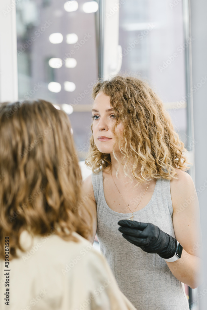 Fototapeta premium The eyebrow master works with the client. The girl performs the procedure of coloring her eyebrows. The concept of the salon and the eyebrows.