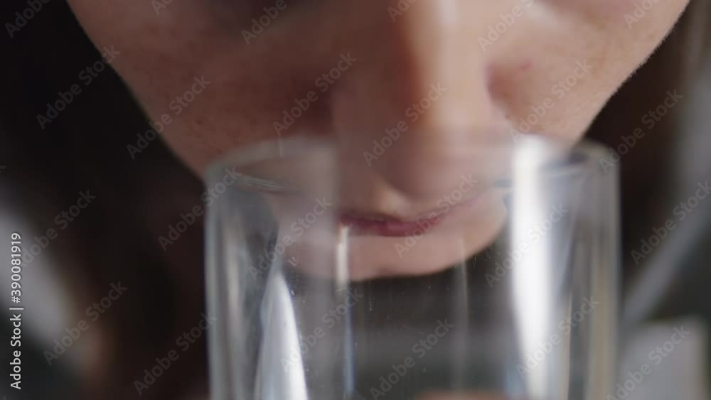 close up of a woman taking a white zinc pill and drinking water close up of a woman taking a white zinc pill and drinking water