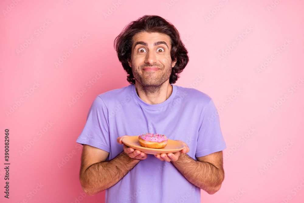 Photo of excited brown haired handsome young man hold donut on plate isolated on shine pink color background Photo of excited brown haired handsome young man hold donut on plate isolated on shine pink color background