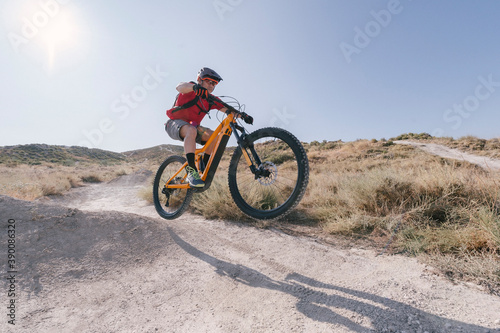 cyclist jumping on trail with electric bike